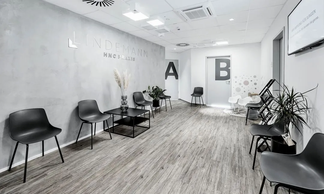 Heller Flur in der HNO-Praxis Lindemann mit modernen, minimalistischen Wandbildern und Zugang zu den Behandlungsräumen.
